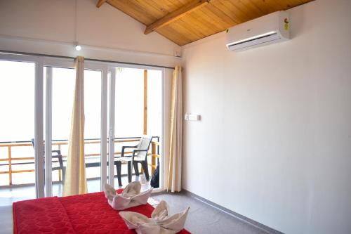 Habitación con cama roja y balcón. en Home De francisco, en Canacona