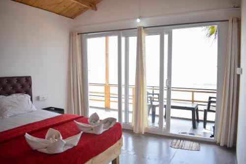 a bedroom with a bed and a large sliding glass door at Home De francisco in Canacona
