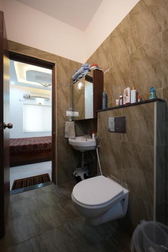 a bathroom with a toilet and a sink at Aayushman Luxury Homes in Sarjāpur