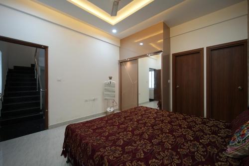 a bedroom with a bed and a staircase in it at Aayushman Luxury Homes in Sarjāpur