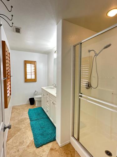 a bathroom with a glass shower and a blue rug at 3 bedroom & 3bath villa near Irvine Spectrum Center UCI in Irvine