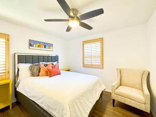 a bedroom with a bed with a ceiling fan and a chair at 3 bedroom & 3bath villa near Irvine Spectrum Center UCI in Irvine