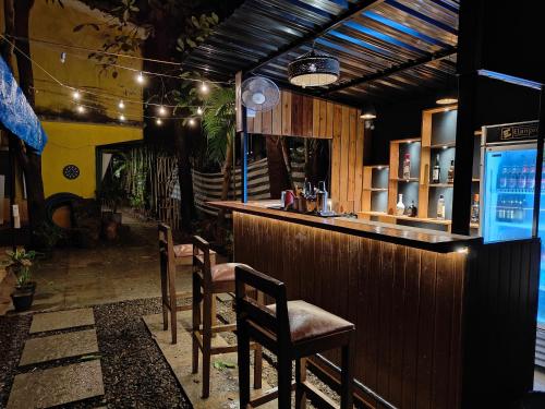 a bar in a restaurant with two chairs and a counter at The goanvibes hostel and cafe in Anjuna