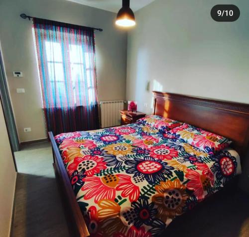 1 dormitorio con 1 cama con colcha de flores en Casina Lubric, en Diano dʼAlba