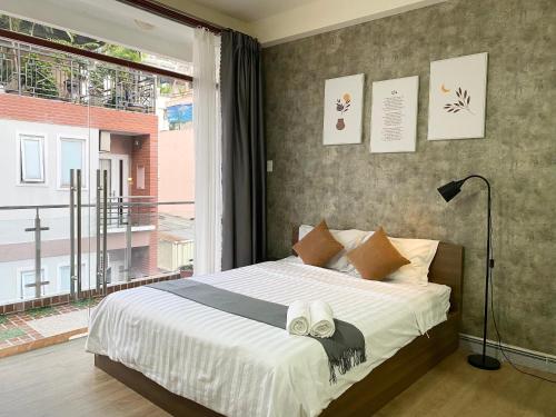 a bedroom with a bed and a large window at Acorn Saigon Hotel - Bui Vien in Ho Chi Minh City