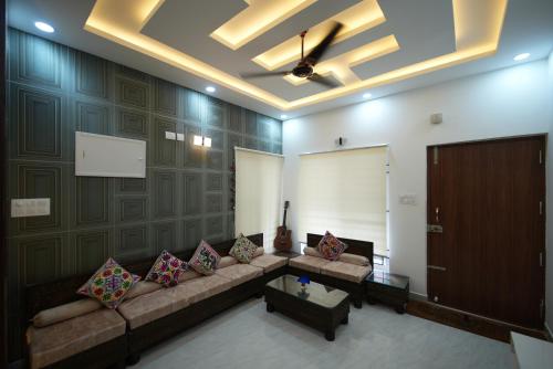 a large living room with a couch and a door at Aayushman Luxury Homes in Sarjāpur