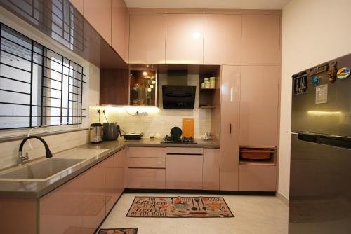a kitchen with white cabinets and a sink and a refrigerator at Aayushman Luxury Homes in Sarjāpur