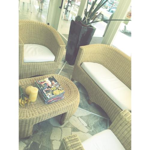 two wicker chairs and a table with a book on it at Hotel Solemare in Cesenatico