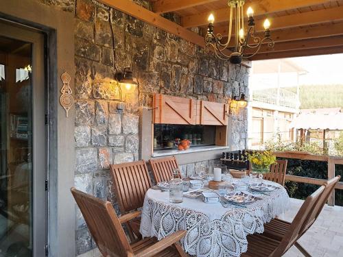 mesa de comedor con sillas y pared de piedra en Bodrum villa en Milas