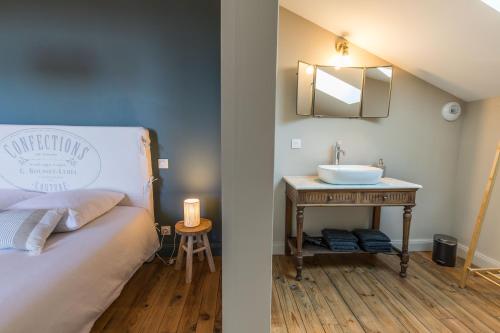 a bedroom with a bed with a sink and a mirror at La maison d'à côté in Mont-de-Marsan