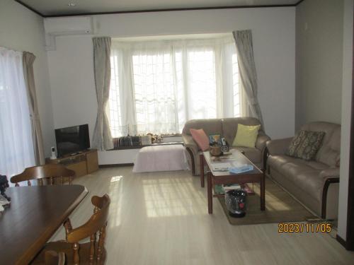 a living room with a couch and a table at 富山駅徒歩9分駐車2台付き一棟貸切素泊り旅館こられ赤江邸 in Toyama