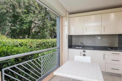 a kitchen with a balcony with a table and a sink at Appartement T1 sur la plage et vue mer in Le Gosier
