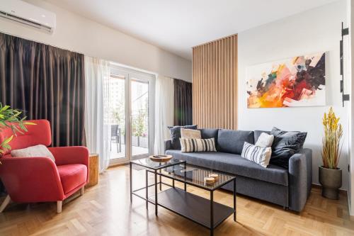 - un salon avec un canapé bleu et un fauteuil rouge dans l'établissement Luxury 2BR Penthouse with City Skyline Terrace, near Kolonaki, à Athènes