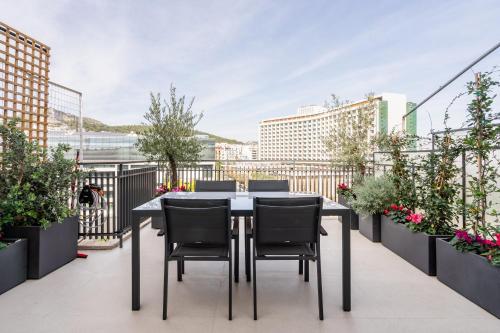 d'une table et de chaises sur un balcon orné de plantes. dans l'établissement Luxury 2BR Penthouse with City Skyline Terrace, near Kolonaki, à Athènes