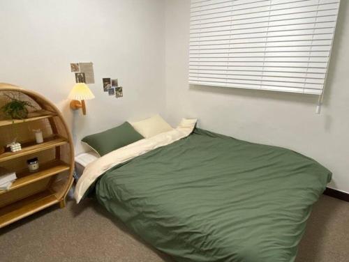 a bedroom with a green bed in a room at Maison de Haenggung in Suwon