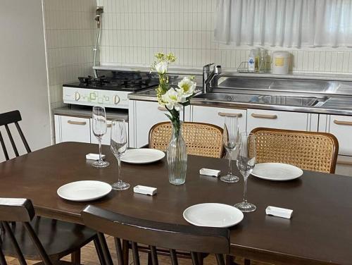 a dining room table with plates and a vase of flowers at Maison de Haenggung in Suwon