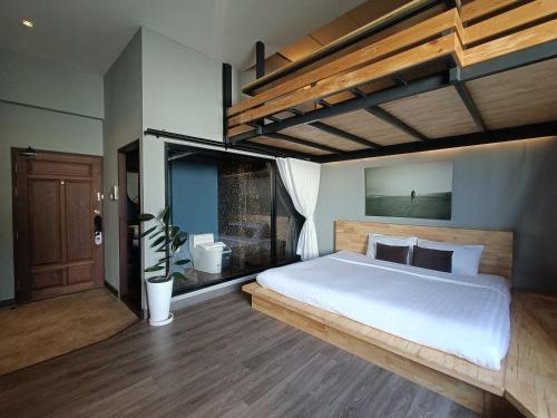 a bedroom with a large bed and a bathroom at 233Poshtel in Lampang