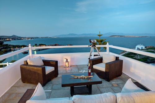 a patio with chairs and a table and a pool at Martineli Residence - A Beachfront Estate in Drios