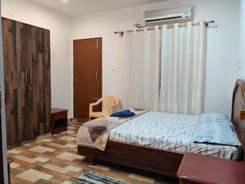 sypialnia z łóżkiem i oknem w obiekcie SkyHouse Homestay w mieście Mysuru