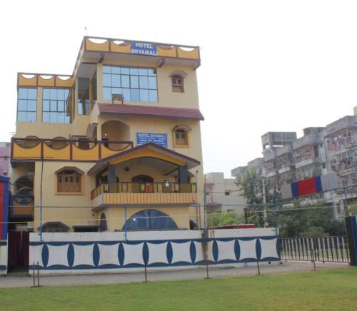 żółty budynek z balkonem na boku w obiekcie HOTEL SHYAMALI AND EVENTS w mieście Dhanbad