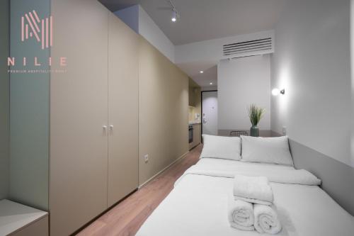 1 dormitorio blanco con 2 camas y cocina en V19, Nilie Hospitality MGMT, en Tesalónica