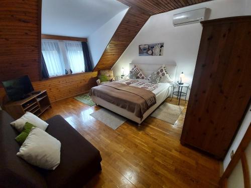 a large bedroom with a bed and a couch at Apartman Őri in Bük