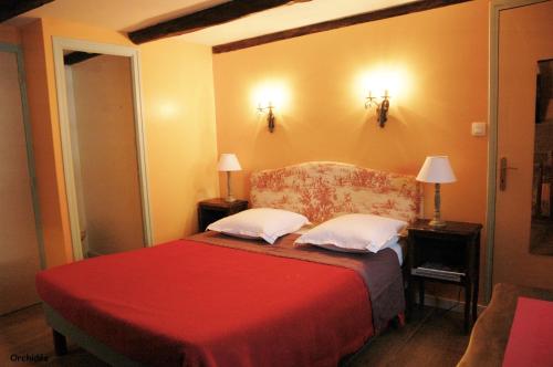 a bedroom with a red bed with two pillows at Chambres d'Hotes Belard in Plonévez-Porzay