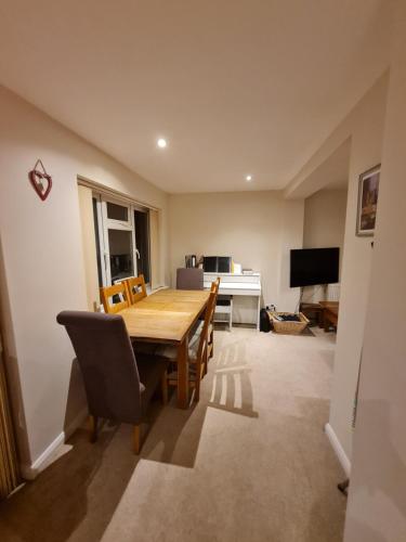 a dining room with a wooden table and chairs at Double Room near Airport in Takeley