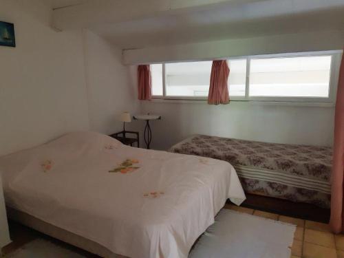 a bedroom with two beds and a window at LE LAVANDOU ST CLAIR MAZET CLIM 5 pers 500 m de mer in Le Lavandou
