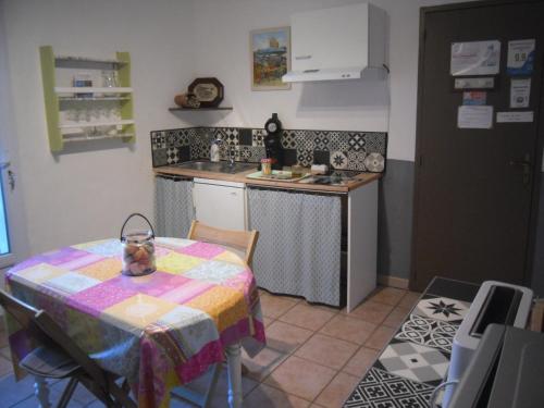 a small kitchen with a table and a sink at chambre les flamants vue sur les étangs petit déjeuner compris in Saintes-Maries-de-la-Mer