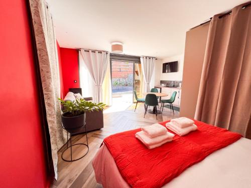 a bedroom with a red wall and a bed with two towels at Résidence Daniza in Saint-Pierre
