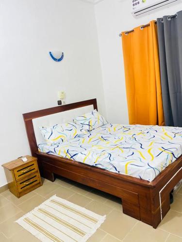 een slaapkamer met een bed met een houten frame bij Charly-Calavi Appartement in Ouékè-Zoumè