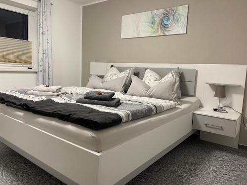 uma cama branca com almofadas num quarto em Hempis Ferienwohnungen em Hochkirch