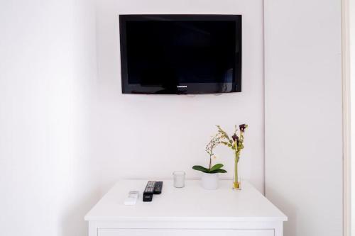 a white cabinet with a flat screen tv on a wall at 'Piccolo Paradiso' in Angera