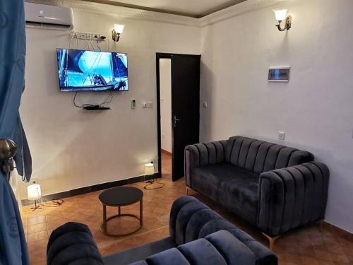 a living room with a couch and a flat screen tv at Charmant,bien localisé et lumineux Appartement F2M/401A in Douala
