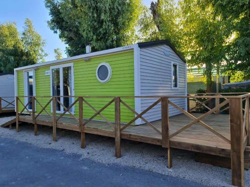 una casita verde y blanca en una terraza de madera en Camping Costa Blanca, en El Campello