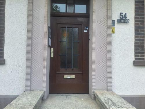una porta marrone sul lato di un edificio di Studio Apartment mit Balkon 13-2L1 a Essen