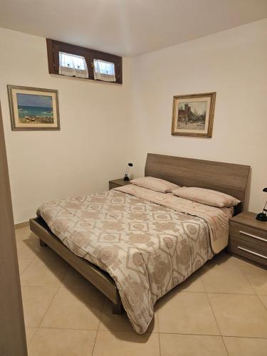 ein Schlafzimmer mit einem Bett und zwei Bildern an der Wand in der Unterkunft Dolce Riposo in Manziana