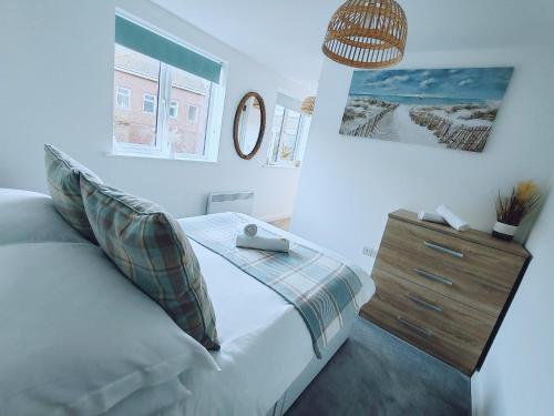 a bedroom with a bed and a dresser and a mirror at Freame House Loft Cosy Easter Getaway Christchurch in Christchurch