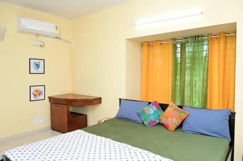 een slaapkamer met een bed met 2 kussens en een raam bij Service apartment in Bangalore