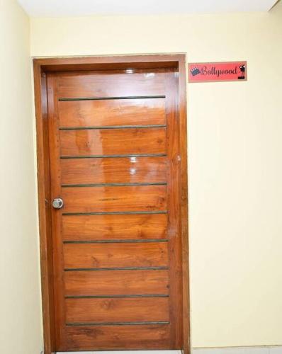 een houten deur in een kamer met een bord erboven bij Service apartment in Bangalore