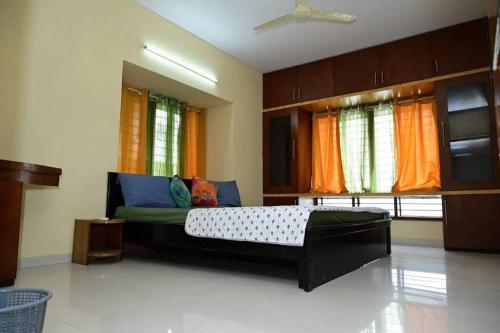 een slaapkamer met een groot bed en oranje gordijnen bij Service apartment in Bangalore
