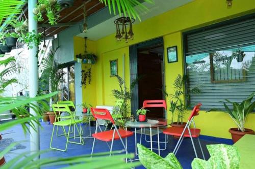 een patio met stoelen en tafels en een gele muur bij Service apartment in Bangalore