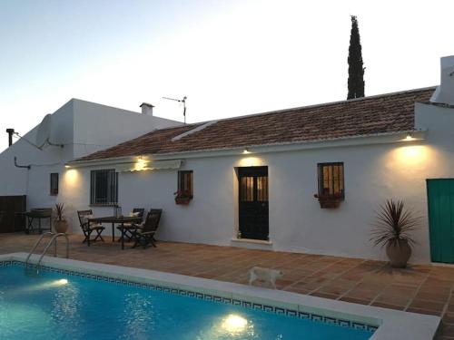 a house with a swimming pool in front of a house at Finca Las Campanas II in Villanueva de la Concepción