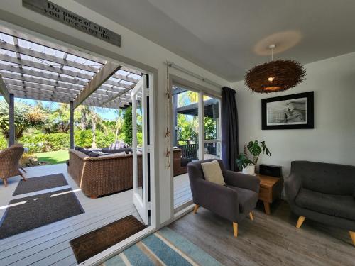a screened in porch with a couch and chairs at Hahei Ocean's 76 in Hahei