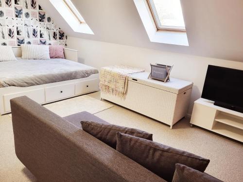 a bedroom with a bed and a couch and a tv at B&B Hoefkamp in Dilsen-Stokkem