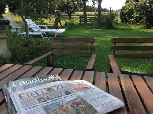 a newspaper sitting on a wooden bench in a yard at All Seasons Bed & Breakfast in Kerpen