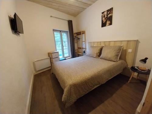 um quarto com uma cama e uma televisão em Gîte La Grange em Chooz