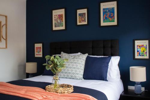 - une chambre avec des murs bleus et un lit avec un vase dans l'établissement Cosy 2-Bed House in Nottingham, à Nottingham