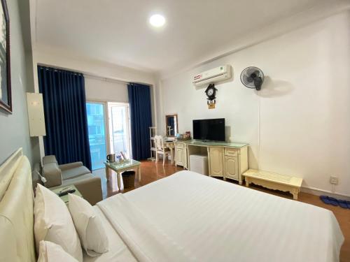 a bedroom with a bed and a desk with a tv at A25 Hotel - 35 Mạc Thị Bưởi in Ho Chi Minh City